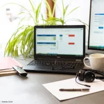 Moderner Arbeitsplatz mit Laptop, Monitor und Büroausstattung veranschaulicht das Thema Homeoffice Kosten steuerlich erfassen und organisieren.